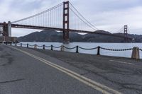 a view of a bridge over a body of water with chain railings around it