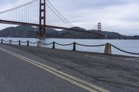 a view of a bridge over a body of water with chain railings around it