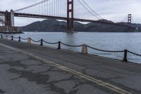 a view of a bridge over a body of water with chain railings around it
