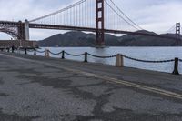 a view of a bridge over a body of water with chain railings around it