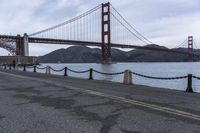 a view of a bridge over a body of water with chain railings around it