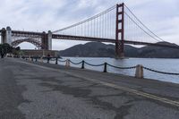 a view of a bridge over a body of water with chain railings around it