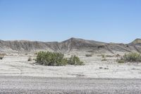 a red truck is driving through the rocky landscape of the desert of an arid area