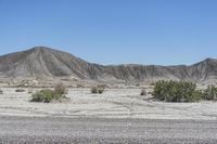 a red truck is driving through the rocky landscape of the desert of an arid area