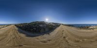 the sun is shining over a sandy area at the beach, with a half - circle image taken from fisheye