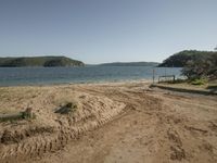 a small sandy beach is by the water and with a sandy shore at the end