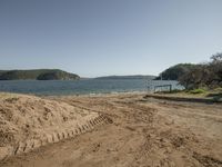 a small sandy beach is by the water and with a sandy shore at the end