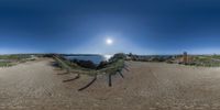 panorama of sand and path with blue sky and water as background on fish eye image