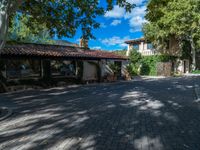 a house is shown with large plants and stone walkways outside it, in the town of santa felibraga