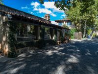 a house is shown with large plants and stone walkways outside it, in the town of santa felibraga