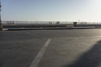 a man riding a skateboard up the side of a ramp in an empty parking lot