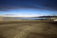 the coast with waves is at the right of this photo, a person riding his motorcycle on the street