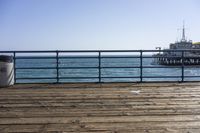 a bench that is sitting in the middle of a pier next to the ocean and water