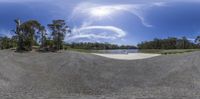 a skateboard is sitting in the middle of a gravel trail, with a sky background