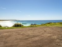 empty road in front of the beach on a sunny day with a clear sky above it