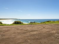 empty road in front of the beach on a sunny day with a clear sky above it