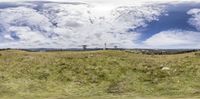 the sky is full of clouds and there are green grass on a hill with trees in it