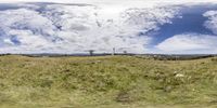 the sky is full of clouds and there are green grass on a hill with trees in it