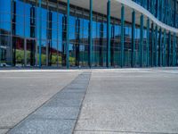 a concrete structure made into rows of orange and yellow poles are on a cement sidewalk