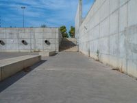 the empty parking lot in front of a wall with apartment buildings on it and a skateboarder on a ramp