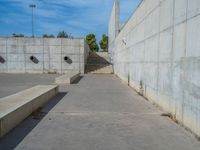 the empty parking lot in front of a wall with apartment buildings on it and a skateboarder on a ramp