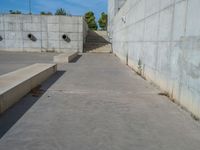 the empty parking lot in front of a wall with apartment buildings on it and a skateboarder on a ramp