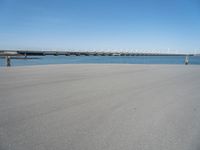 there is a long concrete walkway along the ocean front shoreline of the ocean and dock