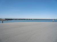 there is a long concrete walkway along the ocean front shoreline of the ocean and dock