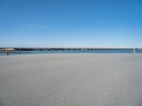 there is a long concrete walkway along the ocean front shoreline of the ocean and dock