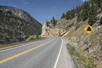 a road with a yellow sign on it that is on the side of the road