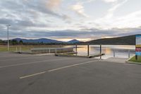 a parking lot next to a mountain in the distance with a lake behind it,