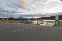 a parking lot next to a mountain in the distance with a lake behind it,