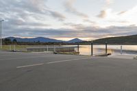 a parking lot next to a mountain in the distance with a lake behind it,