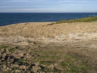 the beach has rocks and rocks and a frisbee in front of it, with the water in the distance