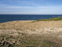 the beach has rocks and rocks and a frisbee in front of it, with the water in the distance