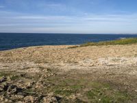 the beach has rocks and rocks and a frisbee in front of it, with the water in the distance