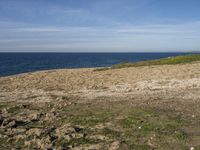 the beach has rocks and rocks and a frisbee in front of it, with the water in the distance