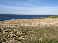 the beach has rocks and rocks and a frisbee in front of it, with the water in the distance