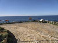 there is a bench on the top of the hill overlooking the ocean and water with no people