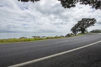 two lanes are lined up on a hill overlooking the water and a sky filled with clouds