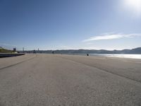 a person sitting on the beach in front of the ocean, looking at the water