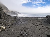 the path to the ocean has rocky beaches and rock formations in it as well as waves and clouds