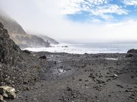 the path to the ocean has rocky beaches and rock formations in it as well as waves and clouds