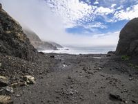 the path to the ocean has rocky beaches and rock formations in it as well as waves and clouds