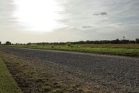 two large grain bins sit in the center of a field, surrounded by silos