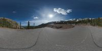 an 360 - turn photo shows a mountain and a wide road between two arrows the way forward