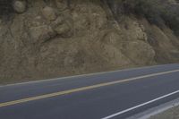a street that has some rocks on it and the road is yellow and white, with a number of two points up to it