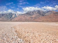 there is a large expanse of rocks in the middle of a desert field with mountains