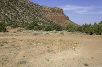 the mountain is high up and is arid with little vegetation in it, and the hills are bare and a few green shrubs stand out