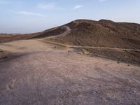 a truck on a dirt road in the desert with rocks and stones on the ground